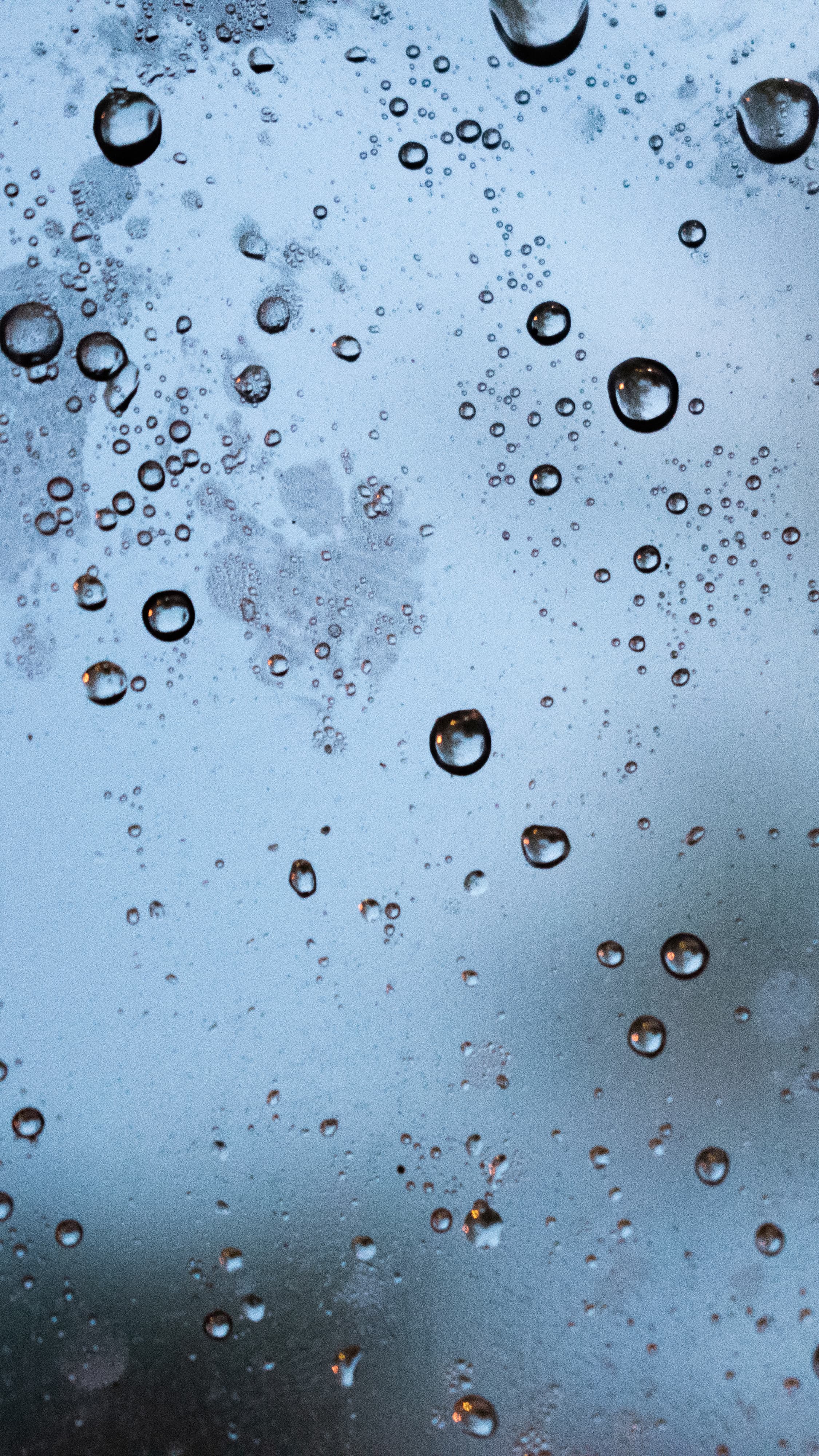 Rain droplets form a calm minimalist texture on glass.