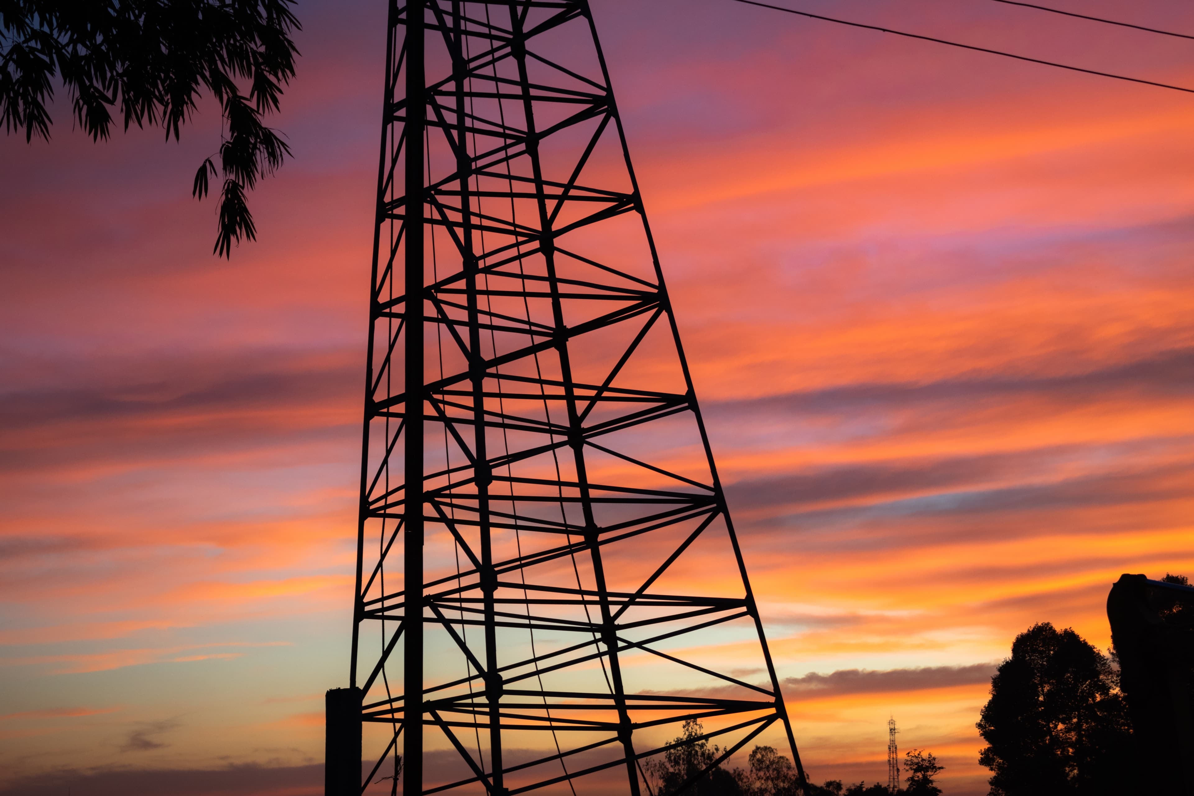 Industrial structures stand against a colorful sky.